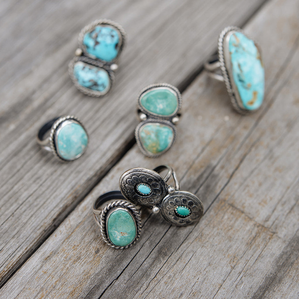 Set of turquoise stone rings on a wooden surface