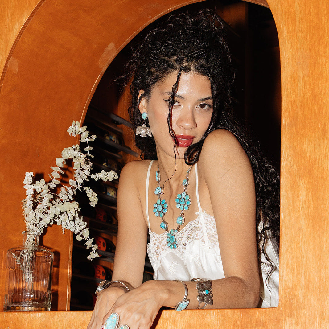 Woman with jewelry sitting in a wooden archway