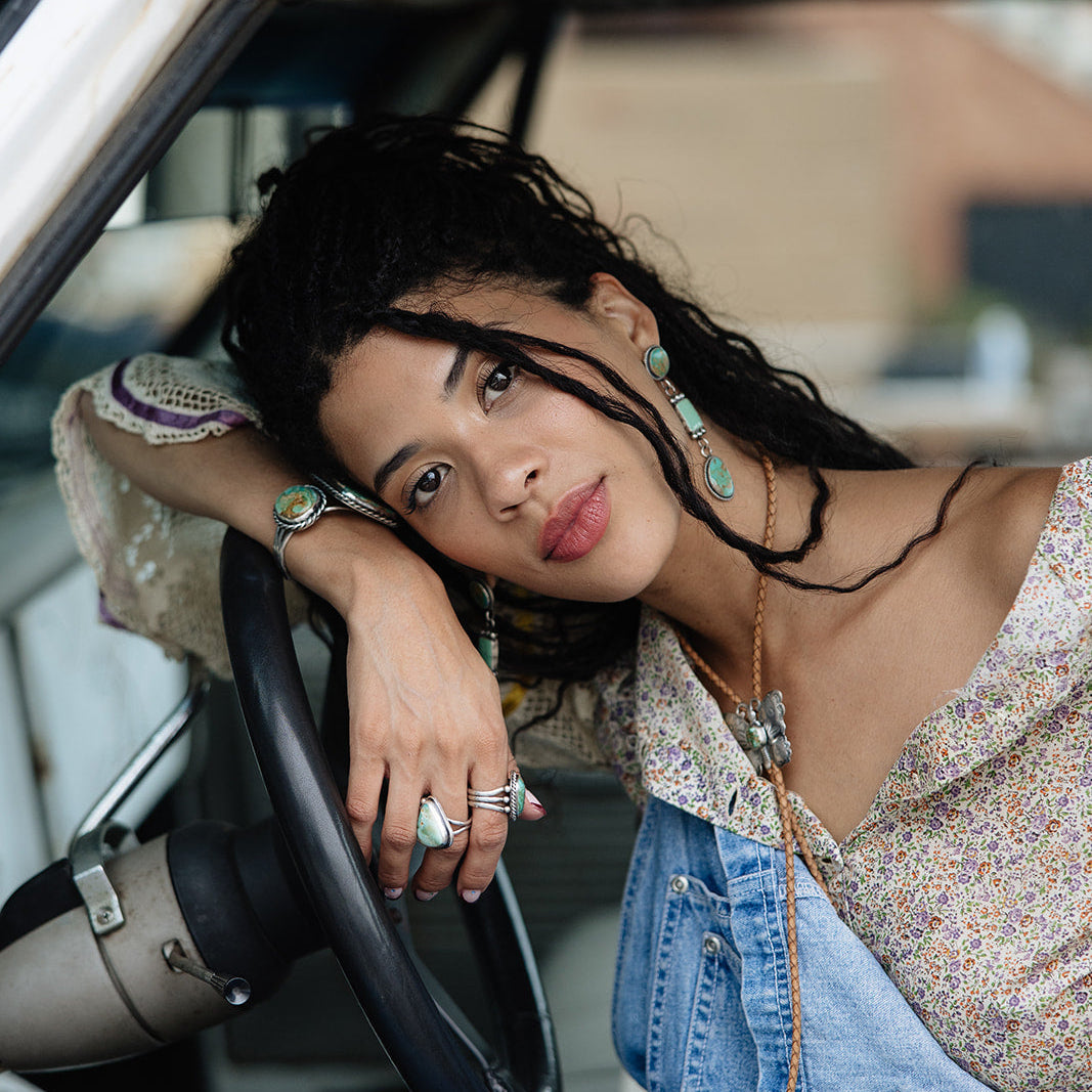 Woman sitting inside a vintage car with a relaxed posture