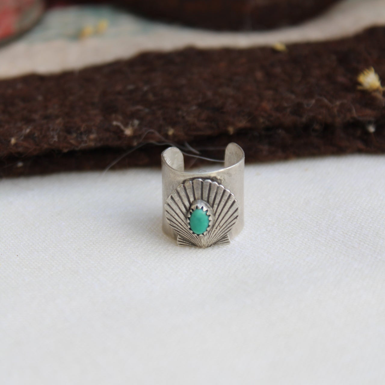 Silver ring with a turquoise stone on a white background