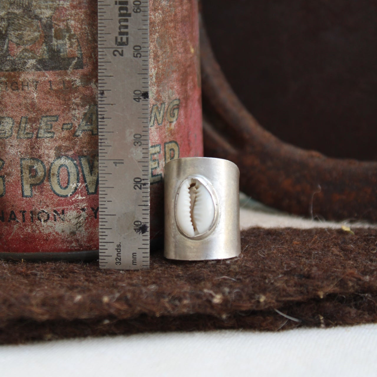 Metallic cylindrical object with a textured surface on a textured background