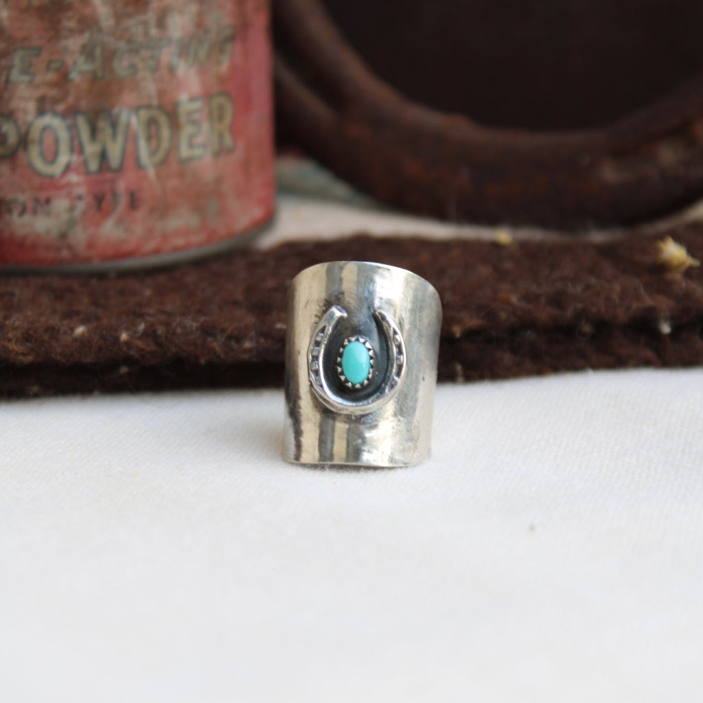Silver ring with a turquoise stone on a white background