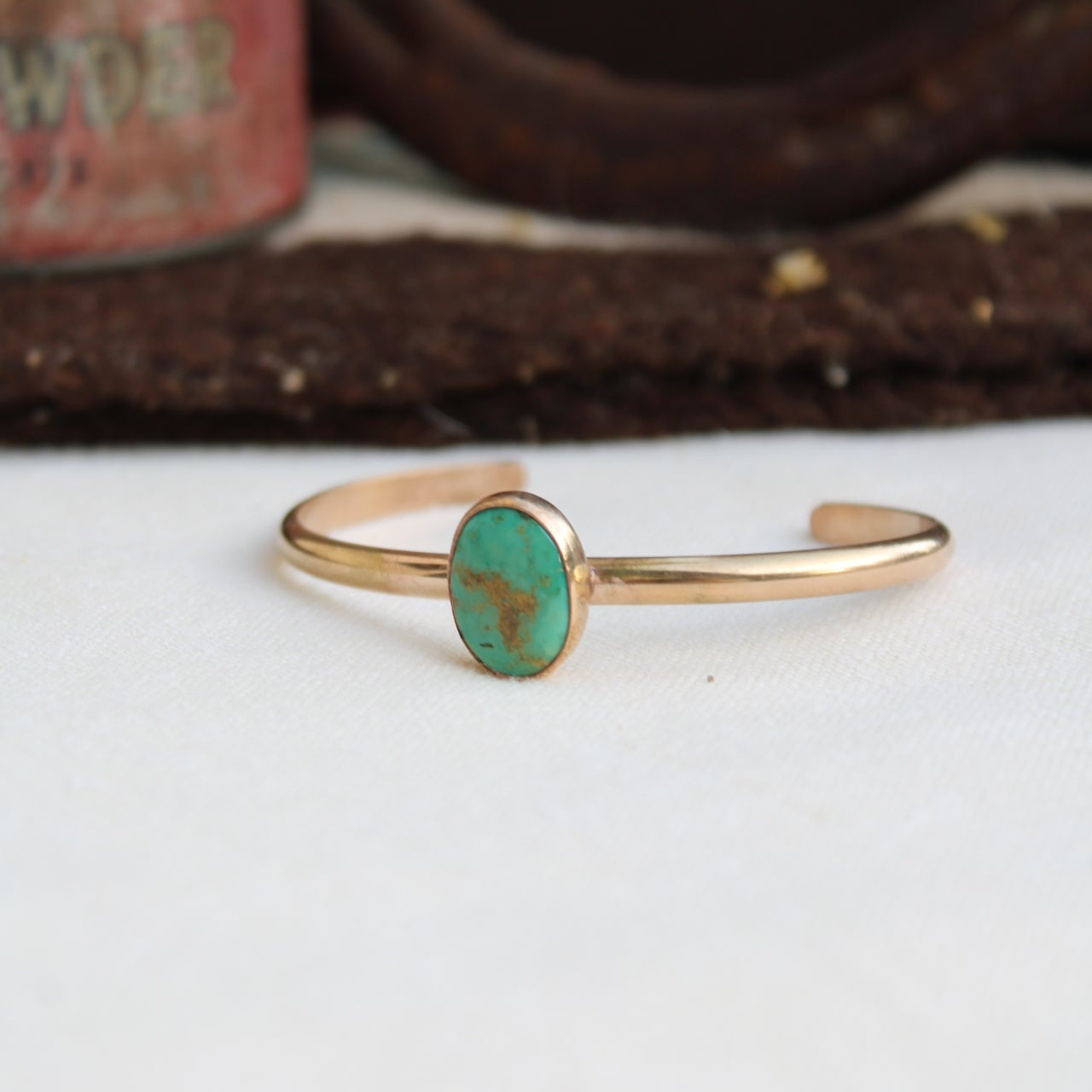 Gold ring with a green stone on a white background