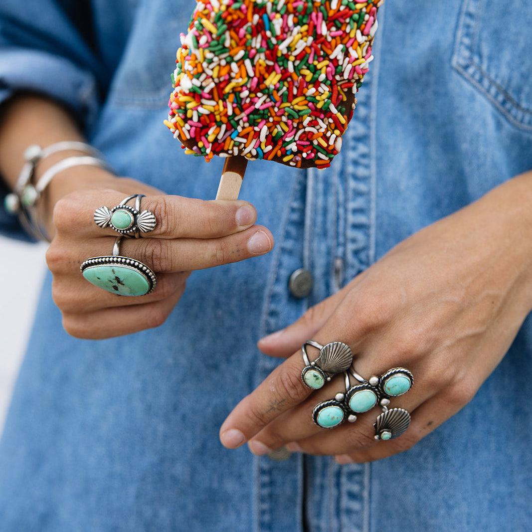 Person holding a colorful sprinkled ice cream bar against a denim background