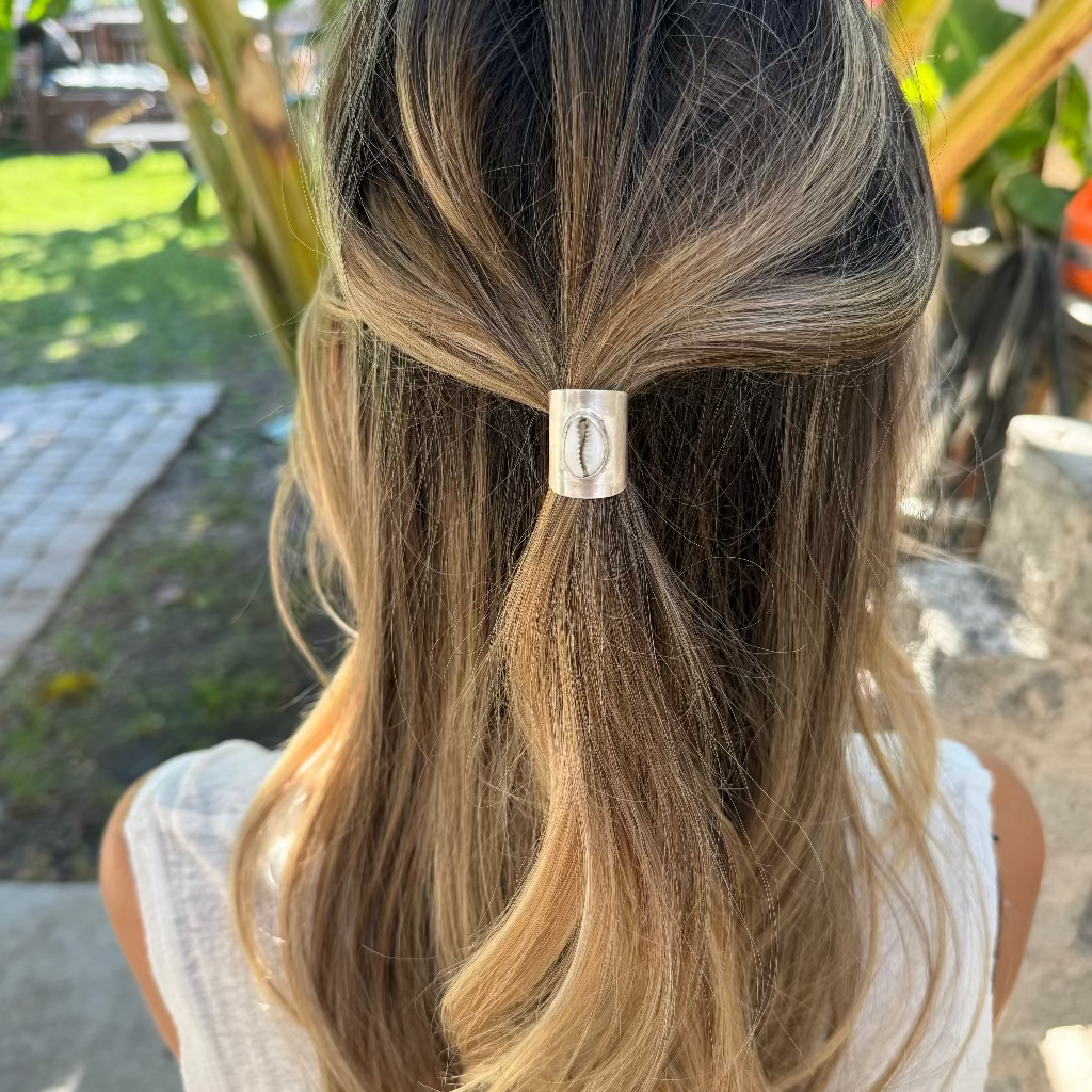 Person with a ponytail held by a hair tie outdoors